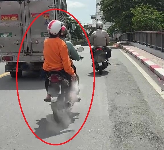 Hình ảnh người phụ nữ rải bột lạ trên đường. Sự việc đang được CSGT xác minh. Ảnh: Đông Hoàng