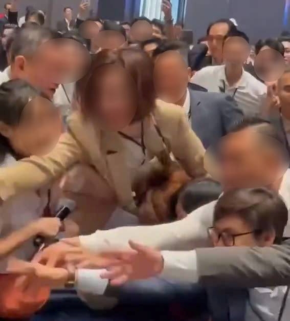 人々がマンション購入登録票を競い合って争うグループの光景。読者提供のクリップから切り取られた写真。