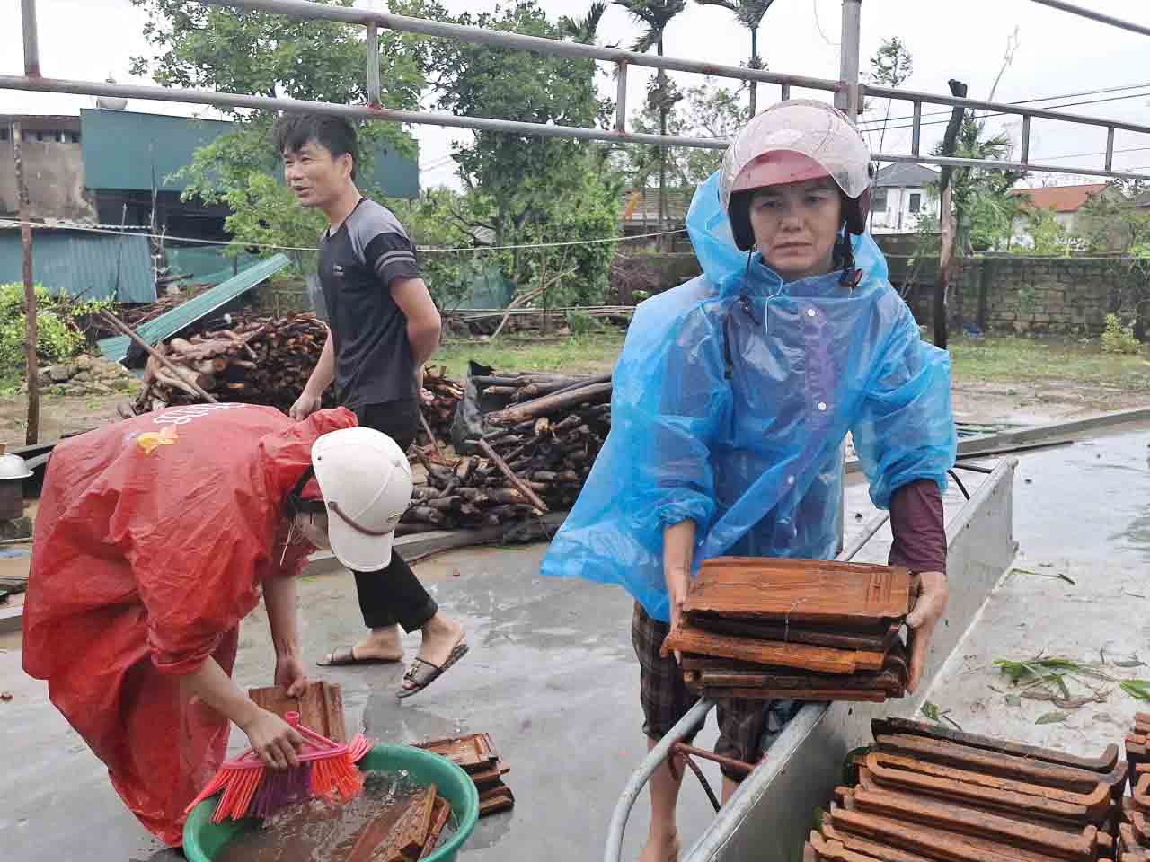 Ms. Quyet's family in Loc Ha commune, Ha Tinh province focused on collecting tiles to re-roof the roof of a house that was blown off by storm No. 10. Photo: Tran Tuan