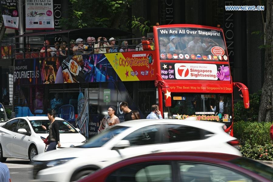 Un bus transportant des touristes sur Orchard Road a Singapour. Cette île vient d'annoncer une population record de 6 11 millions d'habitants. Photo : Xinhua