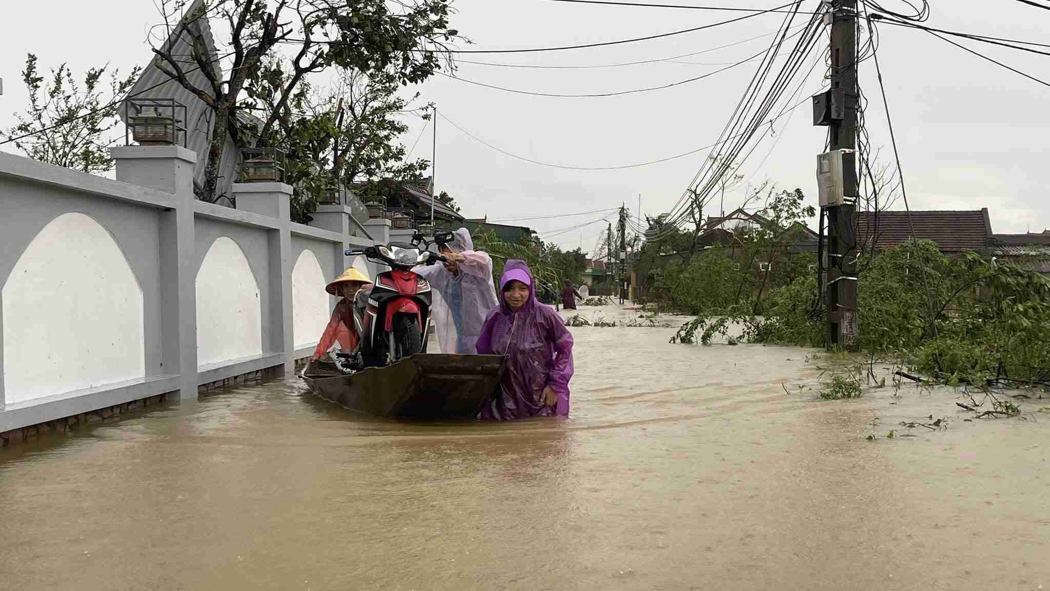 People outside the Lam River dike (Nghe An) use boats to move their property. Photo: Ngoc Anh