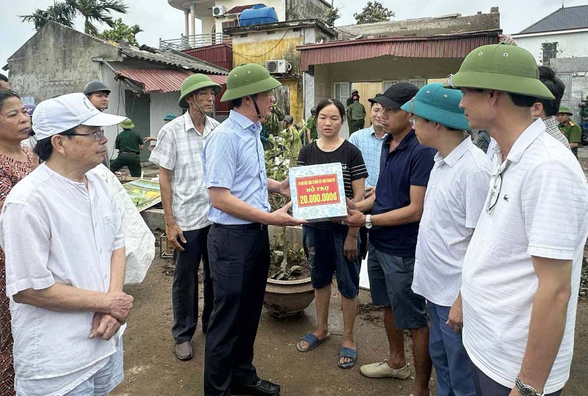 El Presidente del Comite del Frente de la Patria del Sur de la ciudad de Hai Phong entrega 20 millones de VND a hogares completamente destechados. Foto: Comuna de Tan Minh