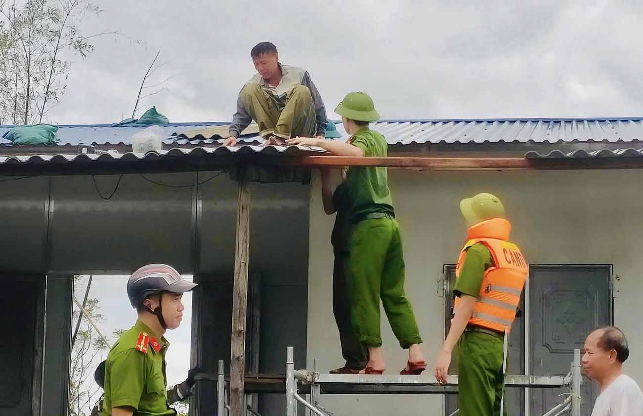 Cong an xa Ky Hoa lop lai nha bi toc mai cho gia dinh ba Dao Thi Nuoc - la vo Liet si. Anh: Cong an Ha Tinh.