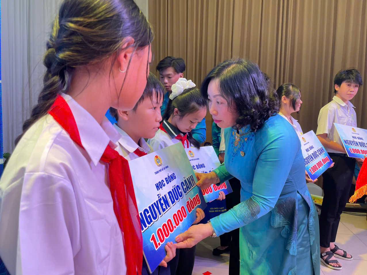 Le vice-president permanent de la Confederation generale du travail du Vietnam Thai Thu Xuong remet une bourse Nguyen Duc Canh a son fils ouvrier de Ho Chi Minh-Ville. Photo : Dinh Trong