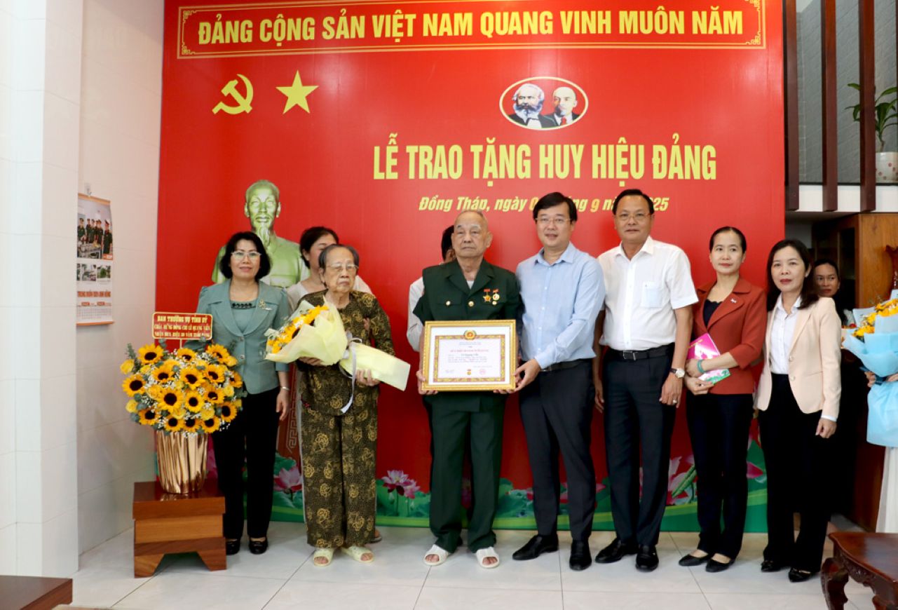 Bi thu Tinh uy Dong Thap Le Quoc phong trao Huy hieu 80 nam tuoi Dang cho Thieu tuong Le Quang Vien. Anh: Cong thong tin dien tu tinh Dong Thap.