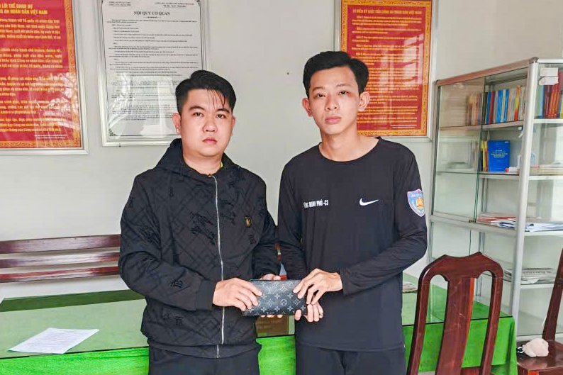 Binh nhi Tang Minh Phu (ben phai) trao tra tai san cho anh Huynh Khanh Huy. Anh: Cong an Can Tho