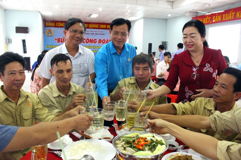 응우옌  띠엔(Nguyen Nhat Tien) 안장(An Giang)성 노동총연맹 부위원장 겸 안장(An Giang)성 노동조합 위원장과 안장(An Giang) 건설 합자회사 기업 노동조합 지도자들이 노동조합 점심 식사에서 노동자들에게 축하 인사를 전하고 있습니다. 사진: 룩 퉁(Luc Tung)
