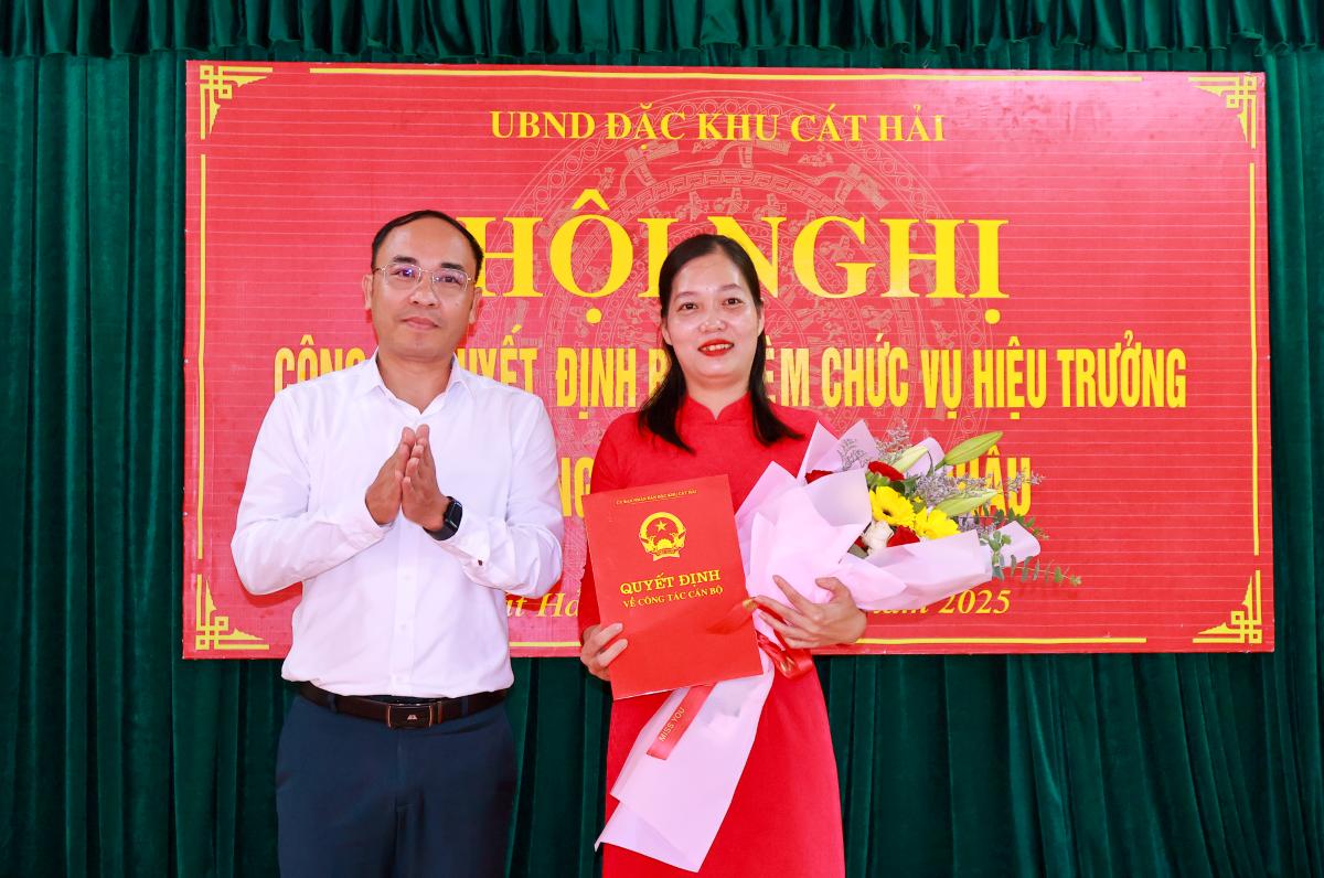 El vicepresidente del Comite Popular de la Zona Especial de Cat Hai entrega la decision a la Sra. Nguyen Thi Duyen directora de la guarderia Tran Chau. Foto: Zona Especial de Cat Hai Hai Hai Phong