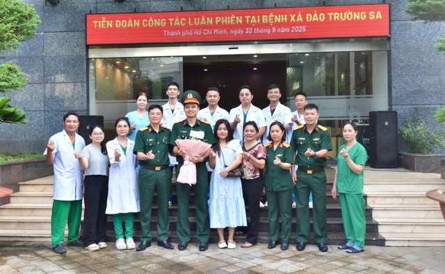 Điều dưỡng Nguyễn Xuân Công (ở giữa cầm hoa) được đồng nghiệp và vợ tham dự lễ tiễn quân làm nhiệm vụ ở Bệnh xá đảo Trường Sa. Ảnh: Nguyễn Ly 