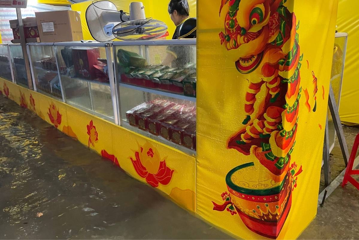 Cac gian hang ban banh trung thu nhanh chong dong goi, dat len cac ke cao nhat tranh tiep xuc voi muc nuoc. Anh: Thanh Binh
