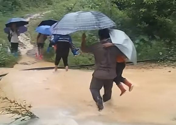 Nuoc ngap sau, giao vien tai xa Thien Hoa, tinh Lang Son phai be, cong hoc sinh qua suoi. Anh: NVCC