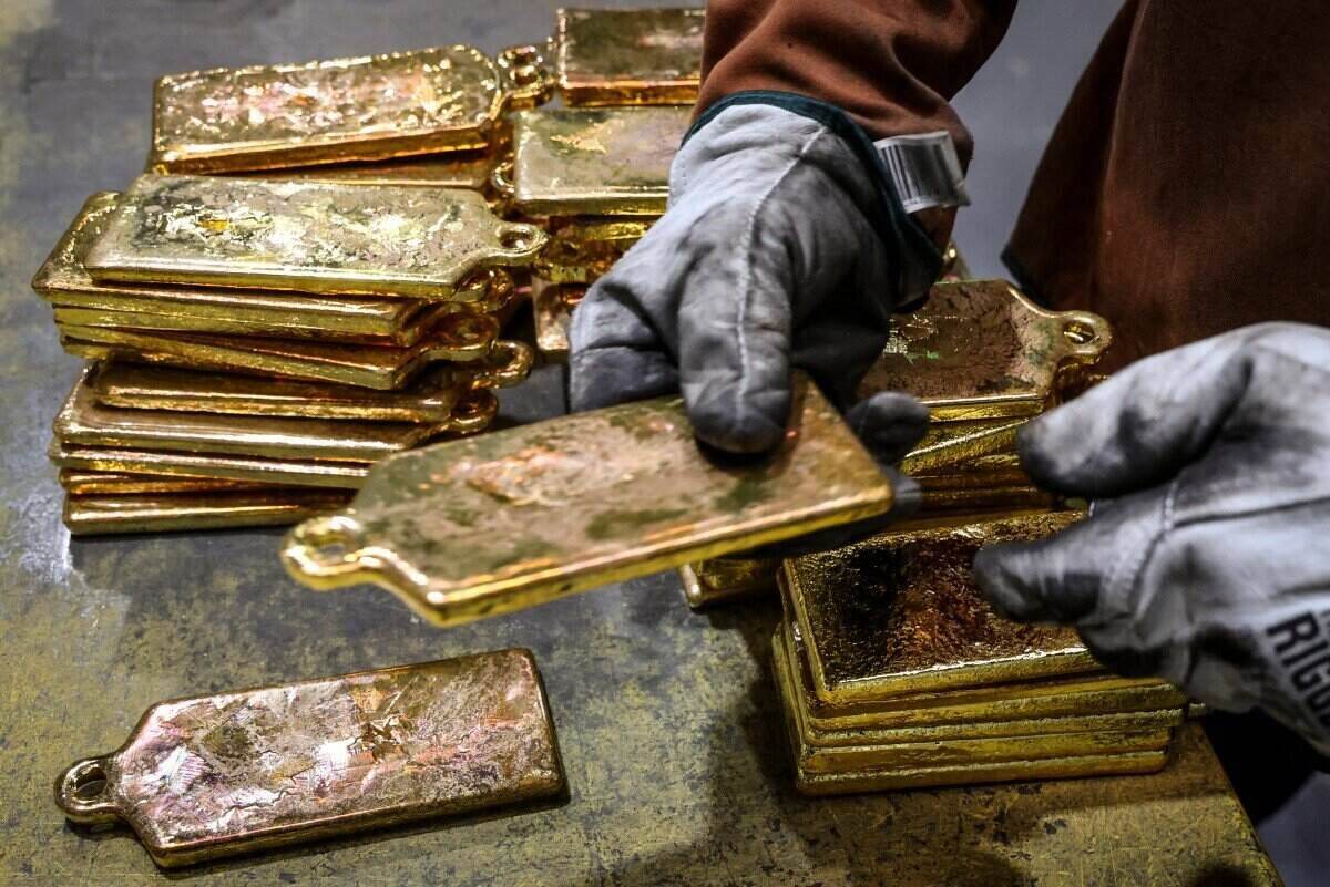 Gold bars are extracted from molds at a gold foundry in Sydney, Australia. Photo: AFP