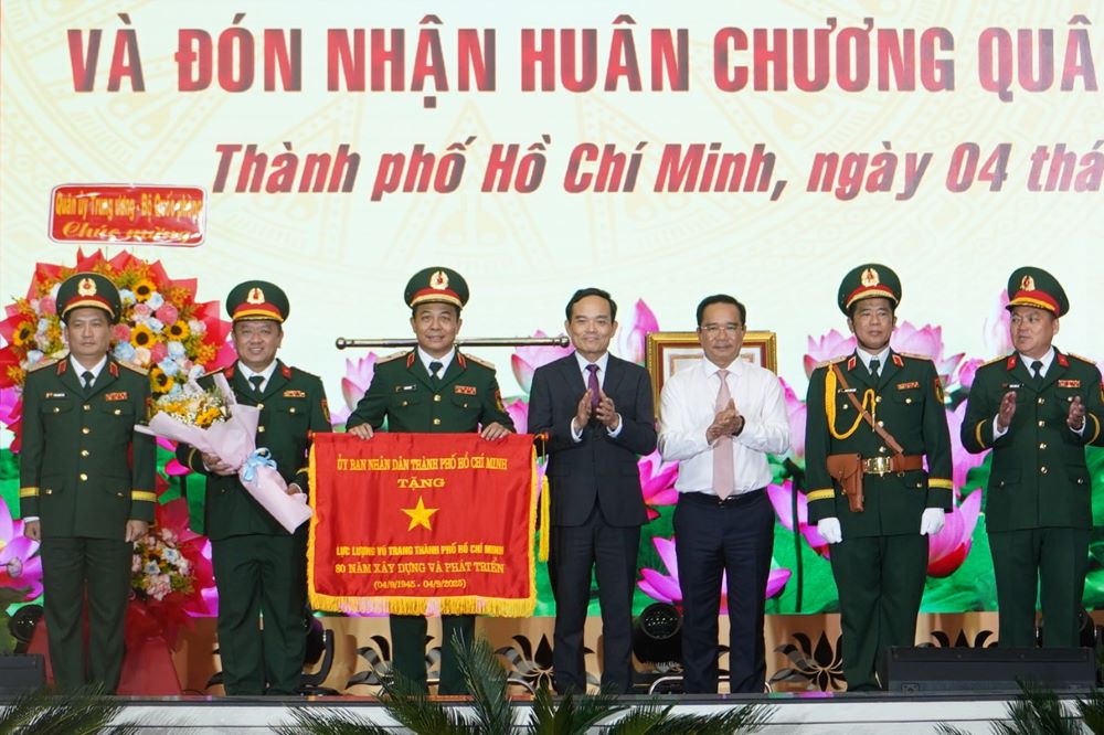 Bi thu Thanh uy TPHCM Tran Luu Quang va Chu tich UBND TPHCM Nguyen Van Duoc trao Co truyen thong cho Luc luong vu trang TPHCM. Anh: Anh Tu