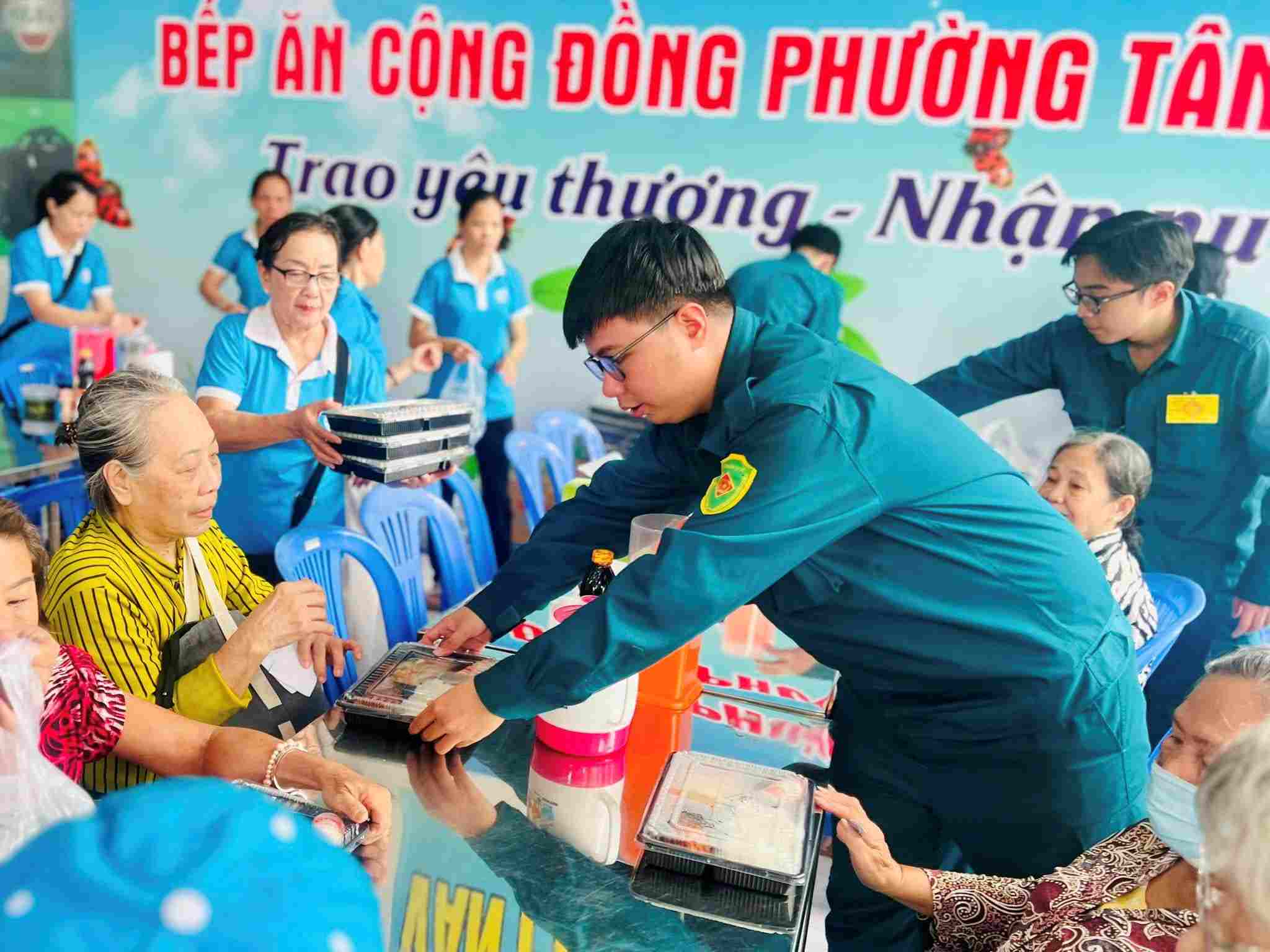 Cac chien si dan quan phuong Tan Son Nhat ho tro trao suat an mien phi cho ba con ngheo. Anh: Minh Tam