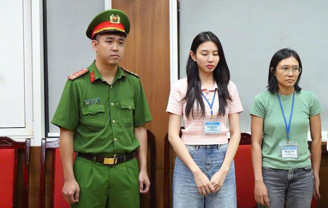 Hoa hậu Nguyễn Thúc Thùy Tiên (giữa) khi bị khởi tố, điều tra tội "Lừa dối khách hàng" và một bị can khác liên quan đến sản phẩm kẹo Kera. Ảnh: Bộ Công an