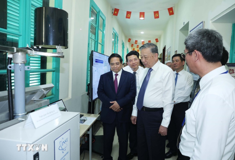 General Secretary To Lam and Prime Minister Pham Minh Chinh listen to an introduction to the applications of nuclear energy for peace. Photo: VNA