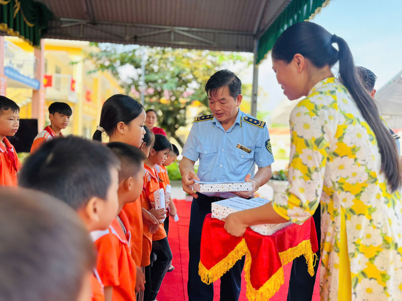 Lanh dao Chi cuc Quan ly thi truong tinh Lang Son trao qua cho hoc sinh Truong TH&THCS Hoa Binh dau nam hoc moi. Anh: Khanh Linh