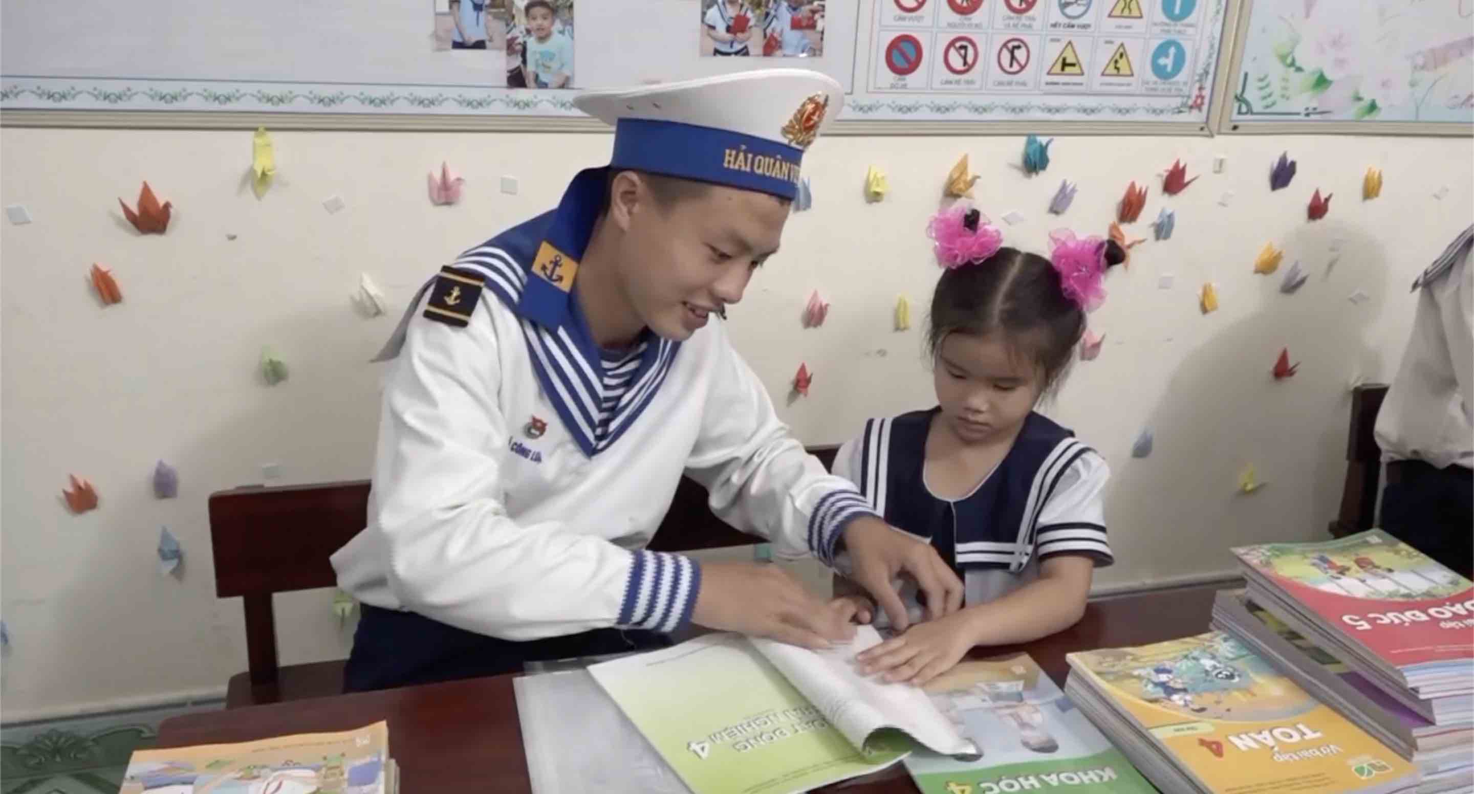 Can bo chien si ho tro hoc sinh tren dao boc sach vo truoc ngay khai giang. Anh: Ngoc Anh