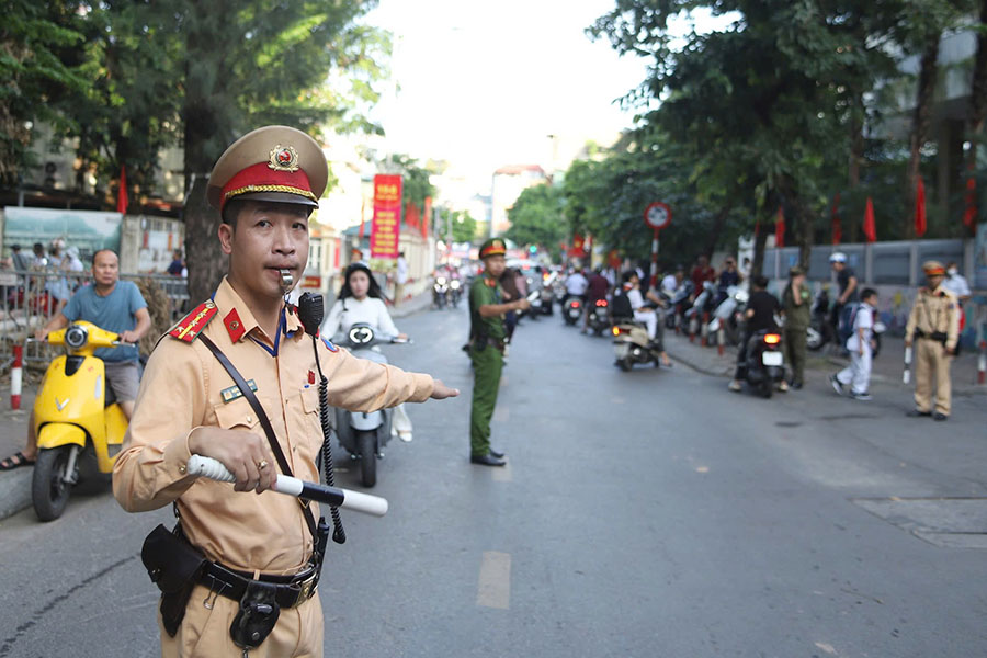 CSGT vua dieu tiet giao thong, vua phat to roi tuyen truyen den phu huynh, hoc sinh trong ngay khai giang. Anh: To The