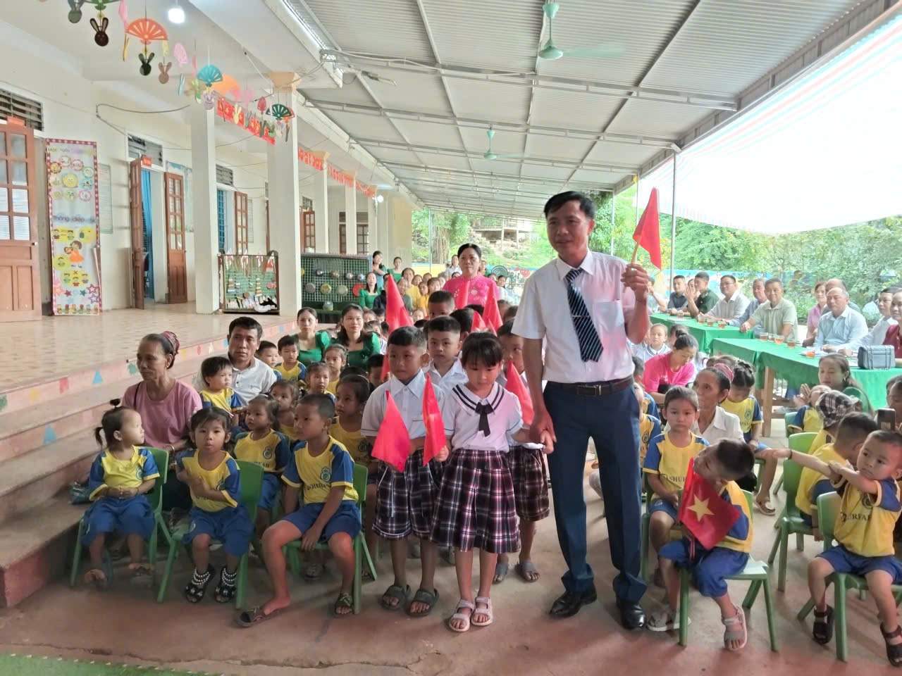 El profesor Tran Sy Ha – Director de la Escuela Primaria DTBT Tieu hoc My Ly 2 (Nghe An) con los estudiantes en la ceremonia de inauguracion del año escolar 2025-2026. Foto: Ngoc Anh