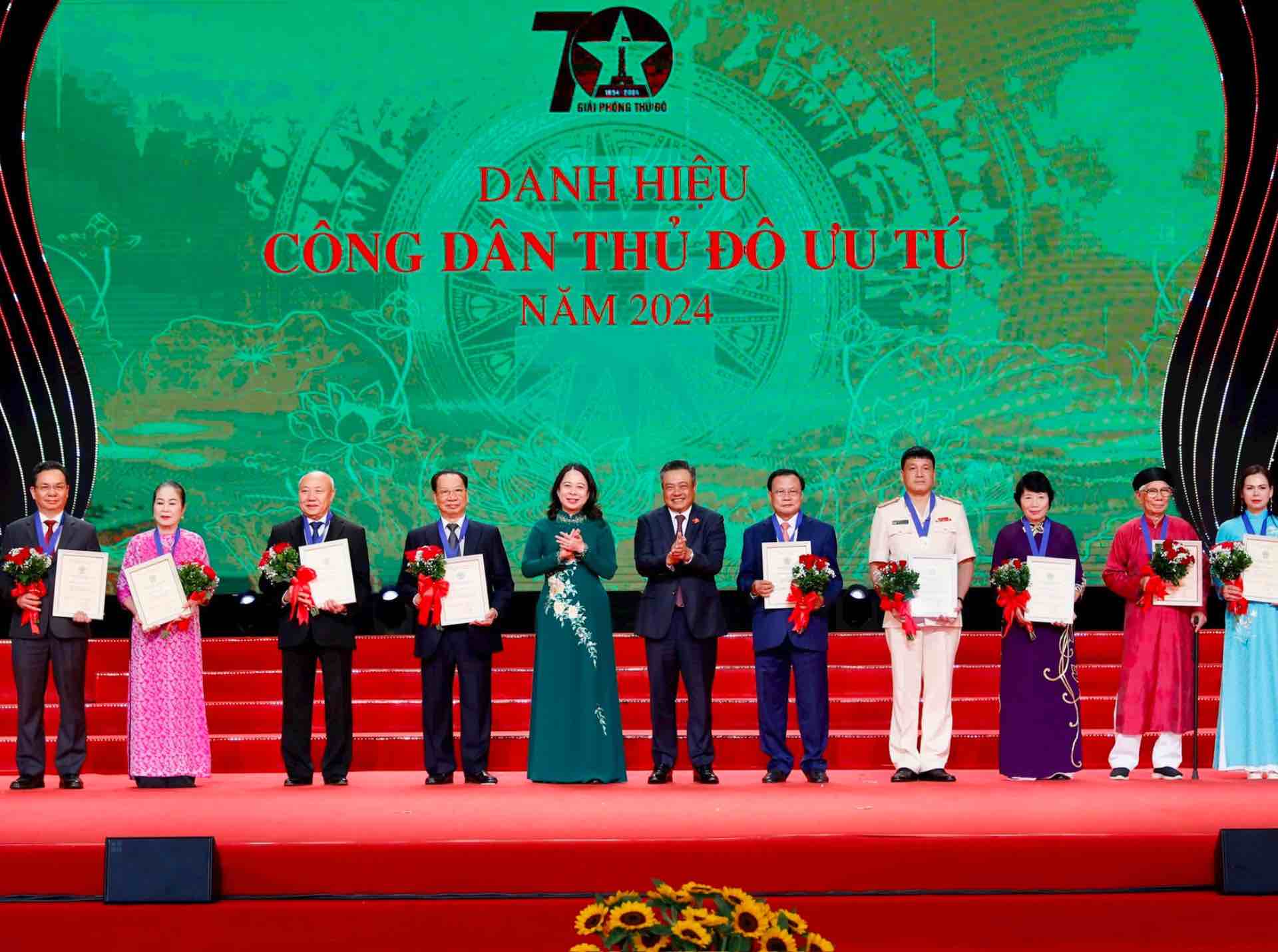 La vice-presidente de la Republique et premiere vice-presidente du Conseil central de la promotion et de la recompense Vo Thi Anh Xuan et le president du Comite populaire de la ville de Hanoï Tran Sy Thanh remettent le titre de citoyen de la capitale emerite en 2024. Photo : Viet Thanh