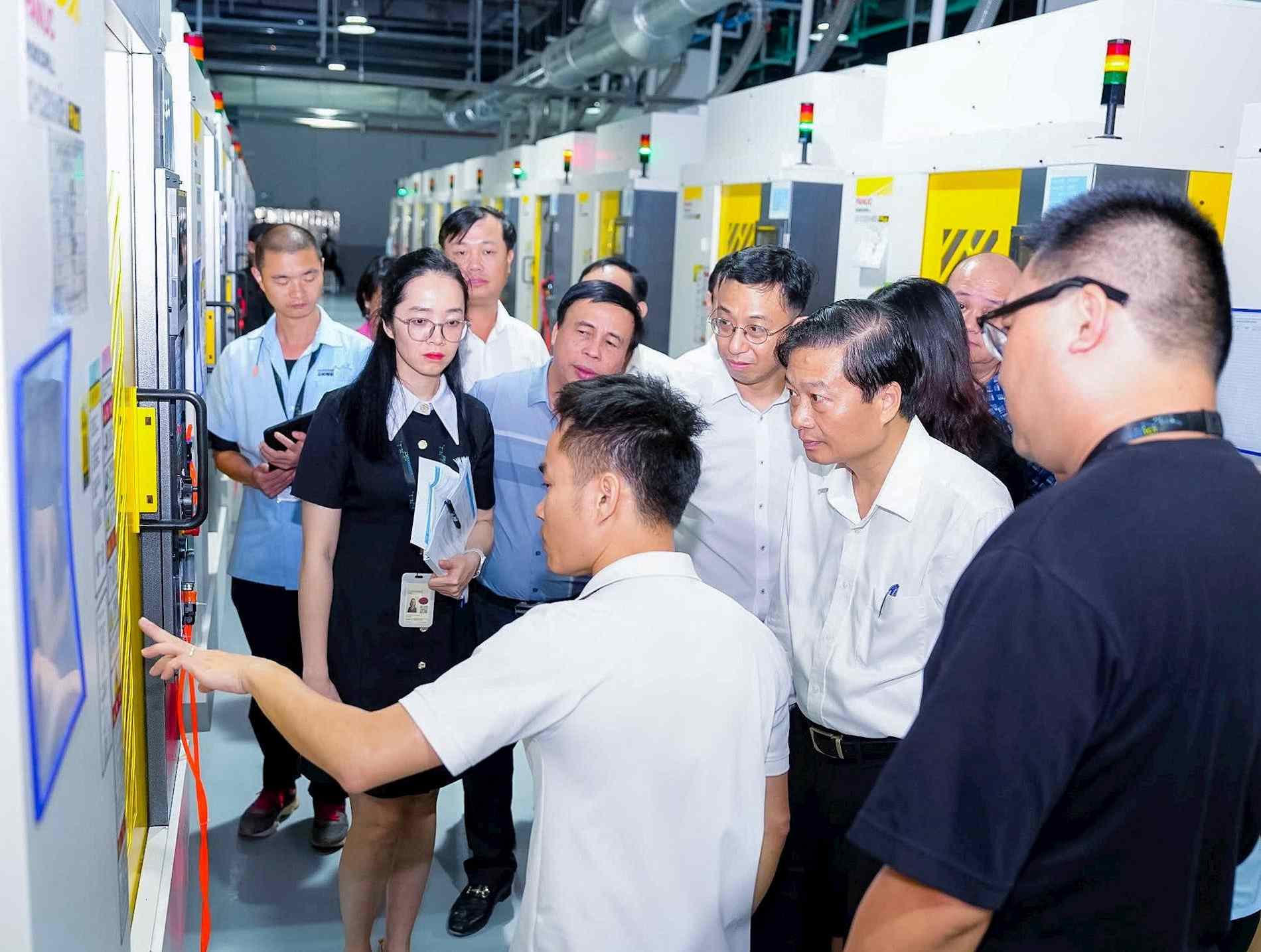 Le president du Comite populaire provincial de Nghe An Le Hong Vinh s'est renseigne sur le systeme d'equipements de production des entreprises de la zone industrielle VSIP Nghe An. Photo : Thanh Duy