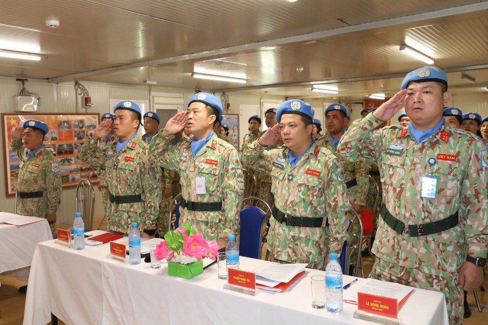 Cac dai bieu va can bo, chien si thuc hien nghi thuc chao co. Anh: Viet Anh