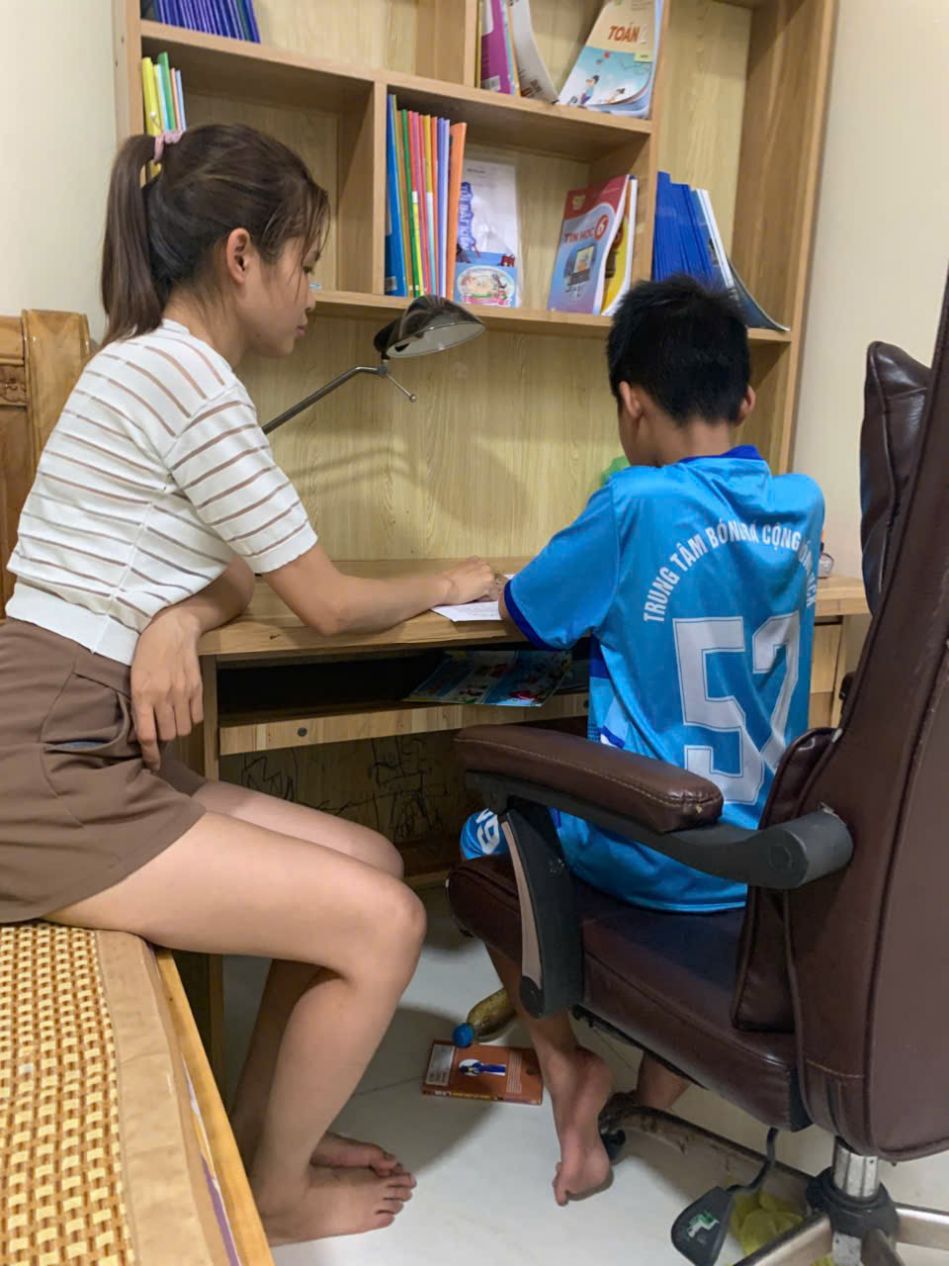 La ouvriere Phung Thi Hanh et ses enfants revisionnent leurs devoirs avant le debut de la nouvelle annee scolaire. Photo : Hanh Phung