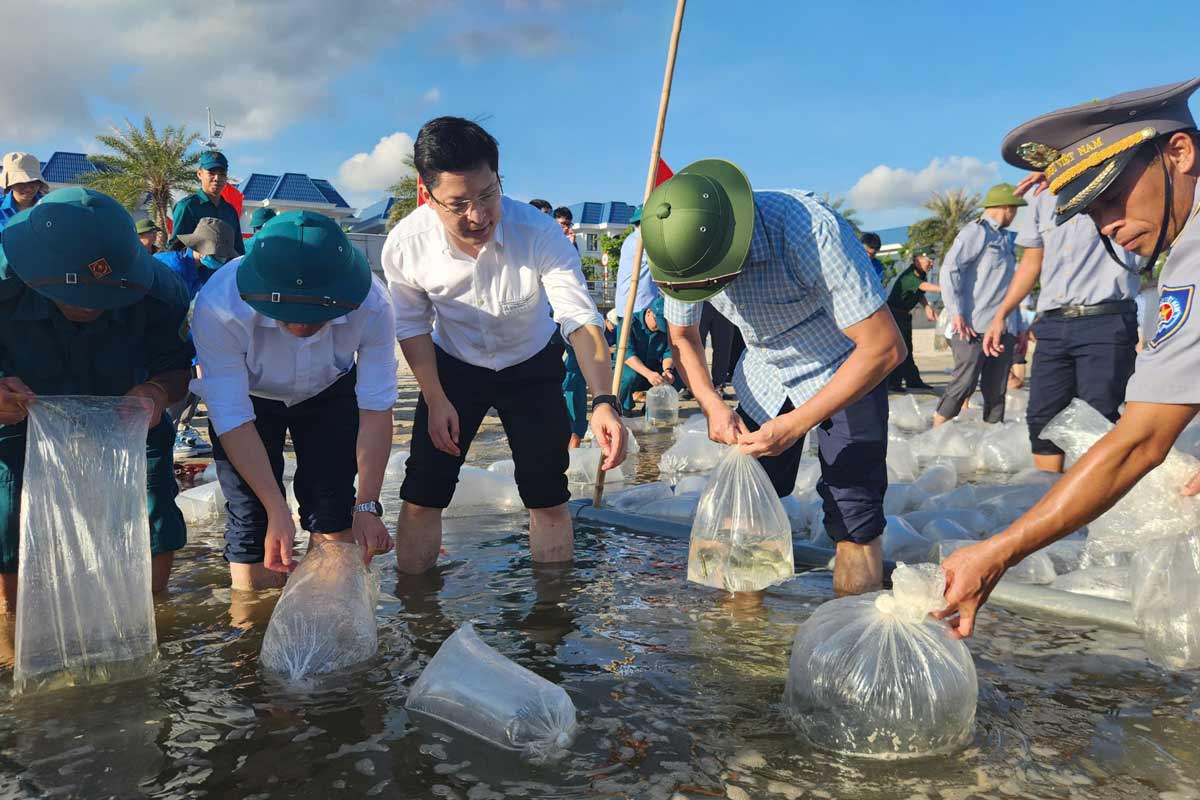 Delegates and people release their breeding animals to the natural waters at Bai Tu Long beach (Quang Ninh). Photo: Doan Hung