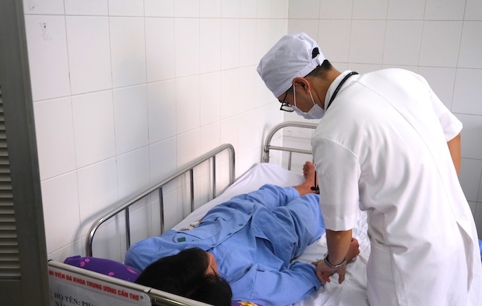 Bac si Khoa Benh Nhiet doi, Benh vien Da khoa Trung uong Can Tho tham kham benh nhan bi sot xuat huyet. Anh: Phong Linh.
