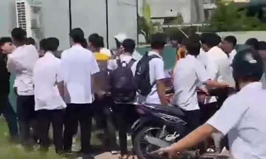 Hơn 10 thanh niên quây dồn ép nạn nhân vào hàng rào khu vực cổng Trường Cao đẳng Việt - Hàn Quảng Ninh. Ảnh: Người dân cung cấp