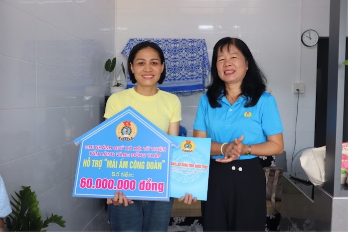 Ba Huynh Thi Tuyet Vui, Chu tich LDLD tinh Dong Thap trao bang tuong trung va quyet dinh ho tro “mai am Cong doan” cho doan vien Tran Thi Tram. Anh: Luu Hung. 