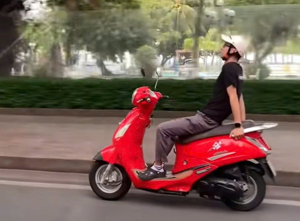 L'action d'un homme qui lache ses deux mains en conduisant une moto. Photo : Huu Long