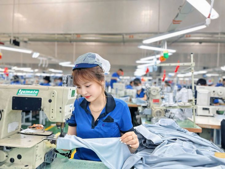 Ouvriers de la societe a responsabilite limitee New Apparel Far Eastern - Vietnam (commune de Dong Phu province de Dong Nai) confectionnant des produits d'exportation. Photo : CDCS de la societe