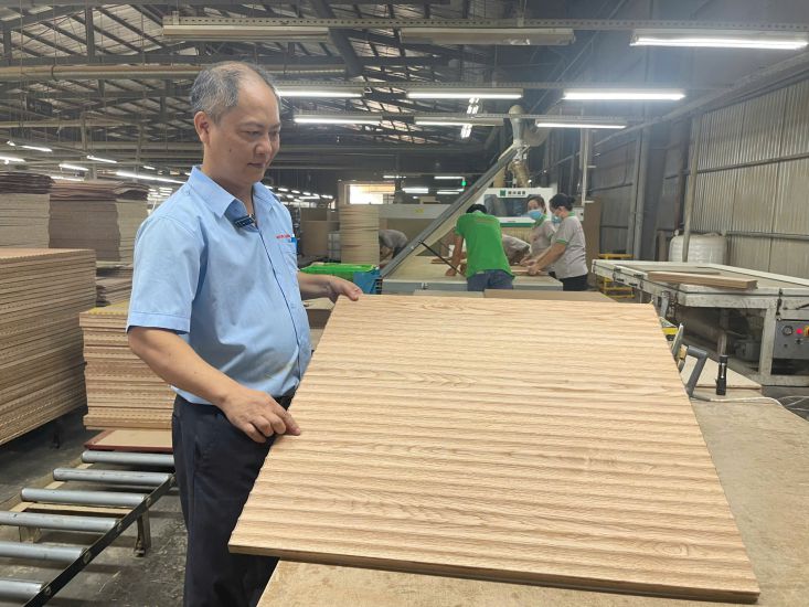 M. Hoang Minh Long presente un produit fabrique a l'aide d'un aspirateur pneumatique qu'il fabrique lui-meme. Photo : Dinh Trong