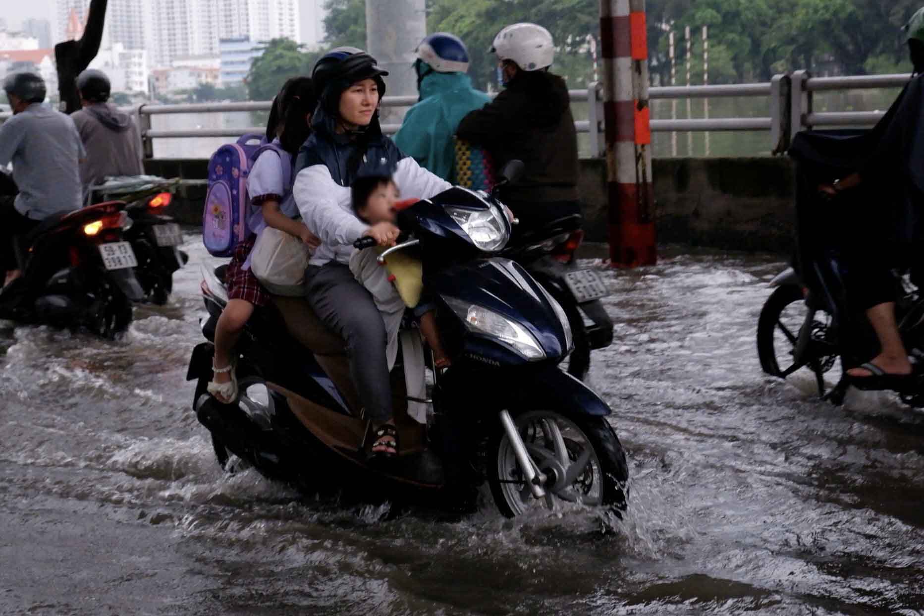 Heavy rain combined with high tides caused flooding, parents in Ho Chi Minh City were busy picking up their children to go home during rush hour. Photo: Tam Quynh