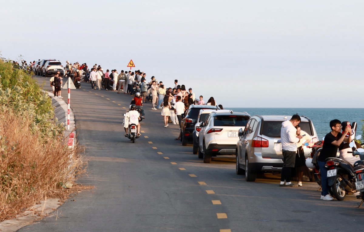 Du khach xep hang dai doc theo con doc de ngam hoang hon tren bien Phan Thiet. Anh: Duy Tuan