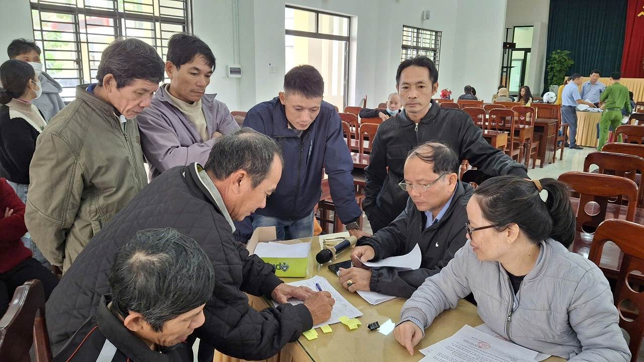 Nguoi dan lam thu tuc ky nhan so tien minh duoc ho tro, ai cung vui mung voi khoang tien nhan duoc. Anh: Vien Nguyen