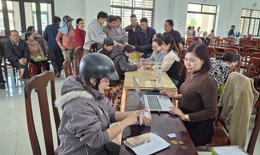 People in Truong Quang Trong ward, Quang Ngai province check the amount of money they are supported with. Photo: Vien Nguyen
