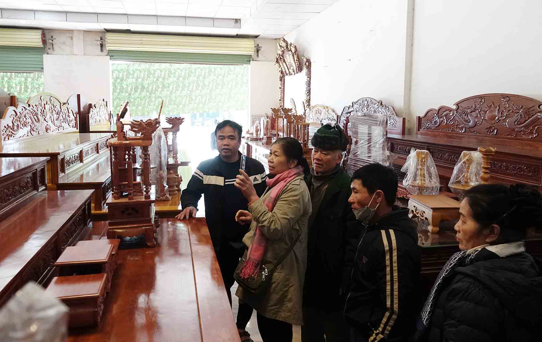 Ong Yen (ngoai cung ben trai) dang gioi thieu san pham la tu tho cho khach hang. Anh: Tran Tuan.