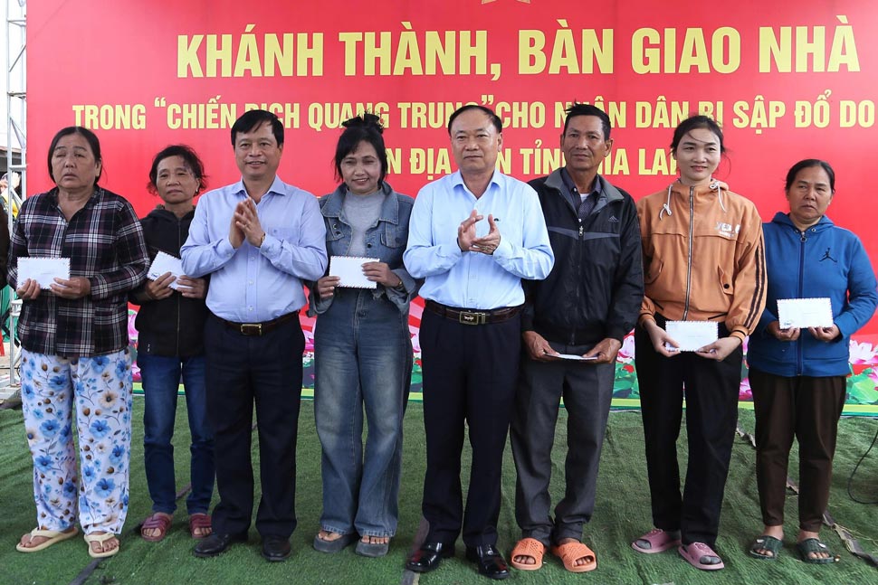 Bi thu Tinh uy Gia Lai Thai Dai Ngoc (o giua) va ong Nguyen Tuan Thanh trao qua cho nguoi dan. Anh: Hoai Phuong