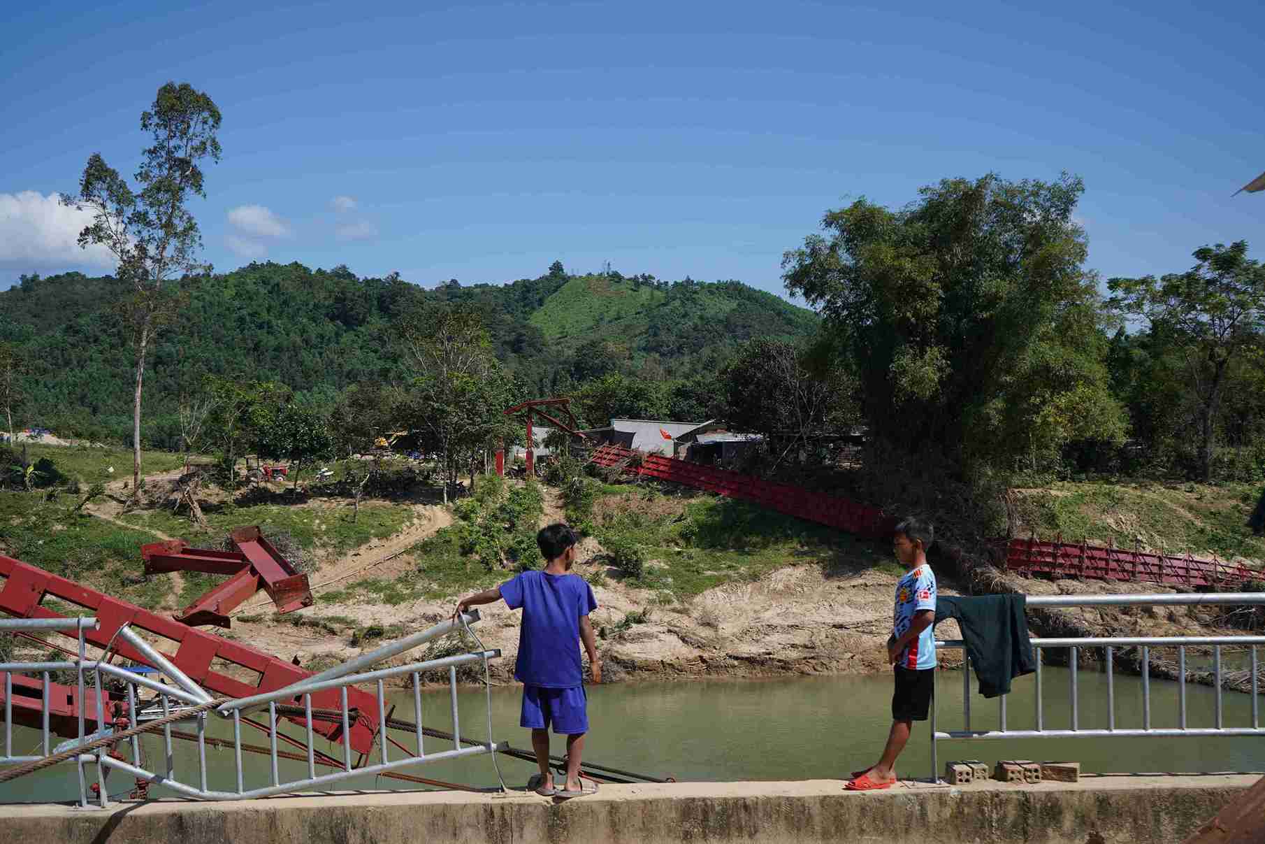 Suspension bridge swept away by floods, people in Nam Khanh Vinh commune, Khanh Hoa province struggle to cross the river. Photo: Huu Long