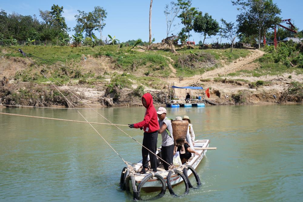 주민들은 배를 타고 밧줄에 매달려 강을 건너고 있습니다.