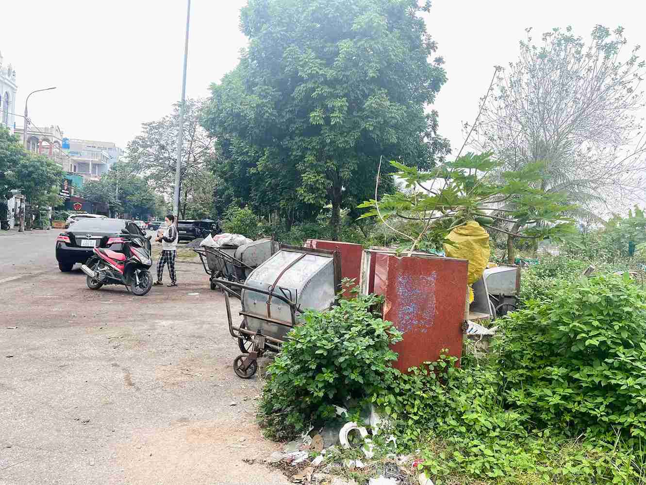 Xe thu gom rác dừng, đỗ trên trục đường Hoàng Thị Loan, phía ngoài khu vực hồ An Vũ.