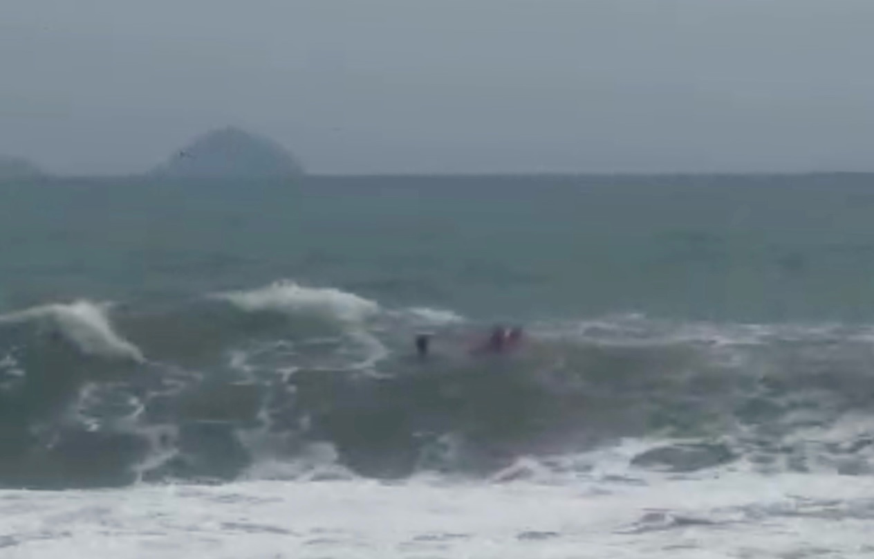 Rescue team rescues tourist swept away by waves.
