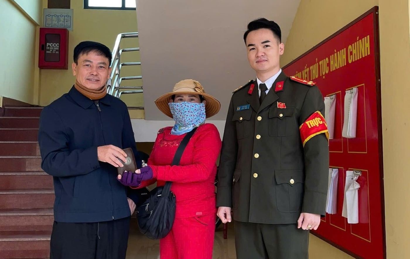 The woman (middle of the photo) selling lottery tickets returns the wallet she found. Photo: Quang Tri Ward Police