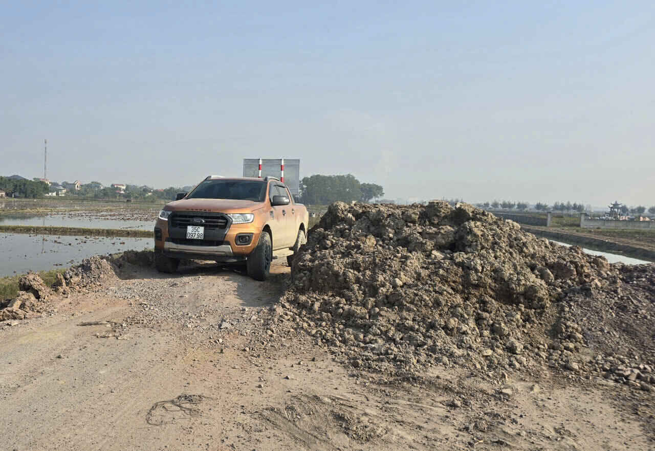 Nhà thầu thi công cho đổ một đống đất to giữa đường tỉnh lộ ĐT482E để chặn các phương tiện qua lại. Ảnh: Diệu Anh