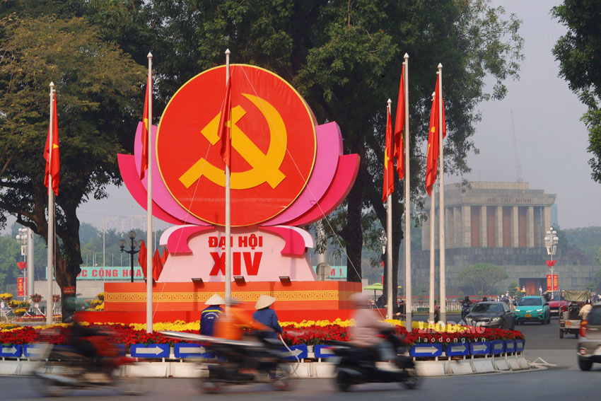 Nhung ngay nay, khap cac tuyen pho tai Ha Noi da khoac len minh mau ao ruc ro don mung Dai hoi dai bieu toan quoc lan thu XIV cua Dang. Tai nut giao Dien Bien Phu - Doc Lap, bieu tuong bua liem cung co Dang, co To quoc duoc bo tri trang trong, phia sau la Lang Chu tich Ho Chi Minh.