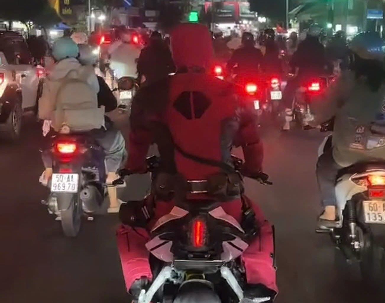 Nguoi dan ong mac trang phuc hoa trang nhan vat Deadpool, che kin tu dau den chan, dieu khien xe tren duong o TPHCM. Anh: PC08 