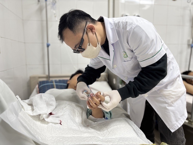 Bac si tham kham cho mot benh nhan bi dap nat ban tay do phao no. Anh: BVCC